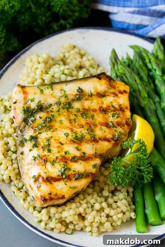 Grilled swordfish served elegantly with couscous and fresh asparagus.