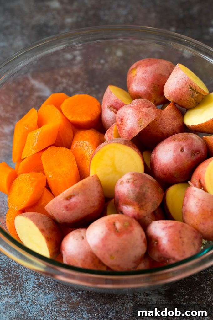 Halved potatoes and sliced carrots in a bowl.