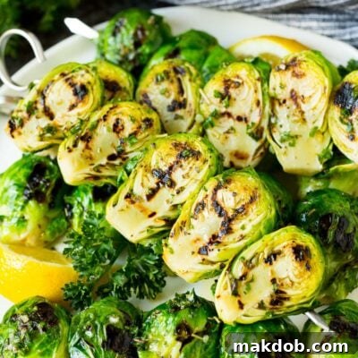 Grilled brussels sprouts on skewers served with lemon and parsley.