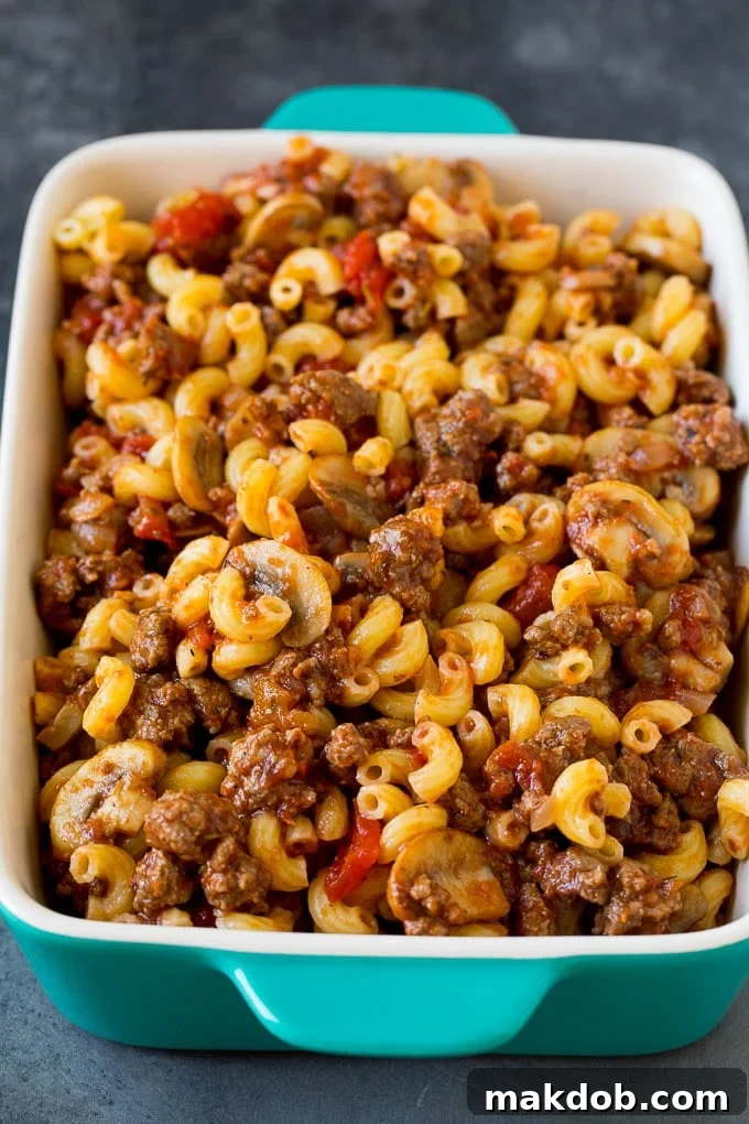The harmonious blend of pasta, ground beef, and tomato sauce before it gets its cheesy topping. Pasta mixed with a ground beef and tomato sauce, ready for baking.