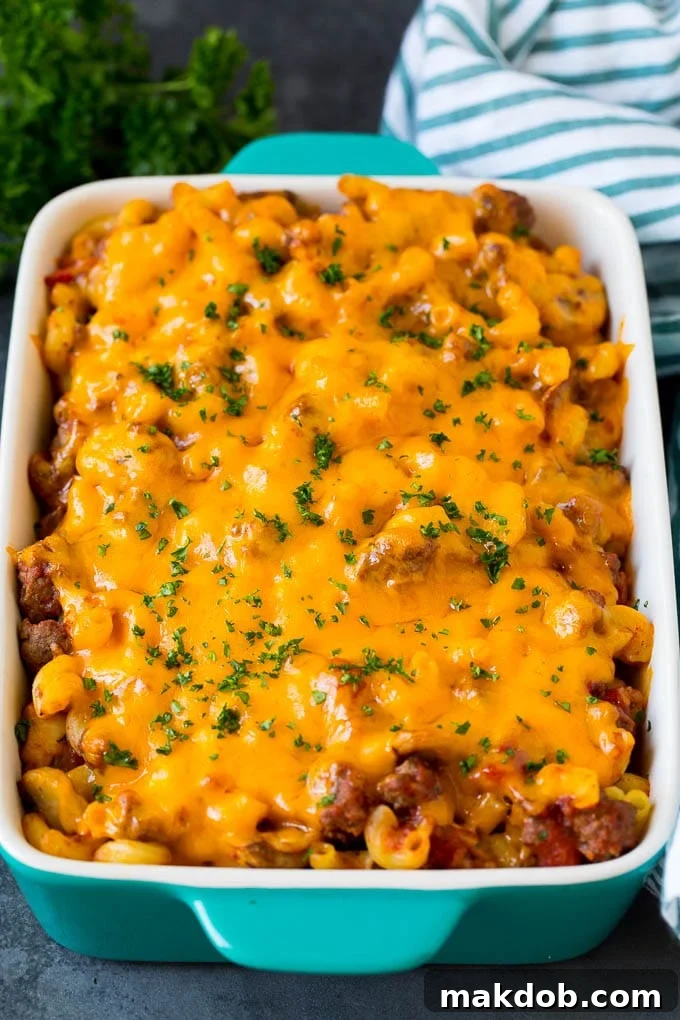 A perfectly baked and cheesy hamburger casserole, a delicious family meal. Hamburger casserole with pasta and ground beef, all topped with melted cheese, ready to be served.
