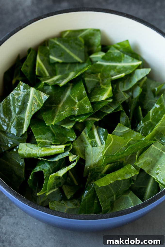 These Southern style collard greens are simmered with bacon and seasonings until tender and flavorful. Freshly chopped raw collard leaves, vibrant green, ready to be cooked in a large pot, anticipating transformation into a tender side dish.