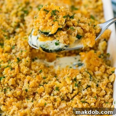 A spoon serving up a portion of zucchini casserole.
