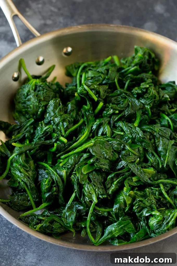 Freshly cooked spinach, perfectly wilted and ready to be incorporated into a creamy sauce.