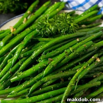 A plate of sauteed green beans with fresh parsley.