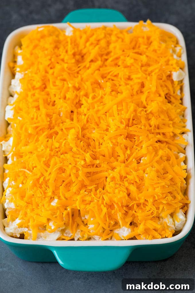 Close-up of creamy potatoes topped with a generous layer of perfectly melted shredded cheddar cheese.