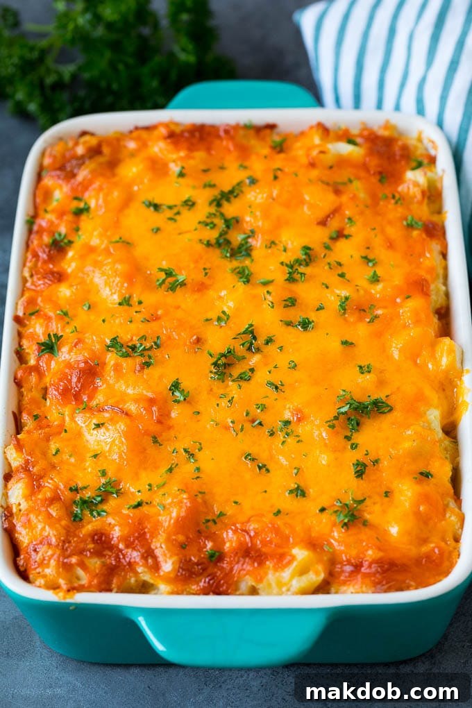 A vibrant cheesy potato casserole in a baking dish, perfectly topped with melted cheddar and a fresh sprinkle of parsley, ready to be served.