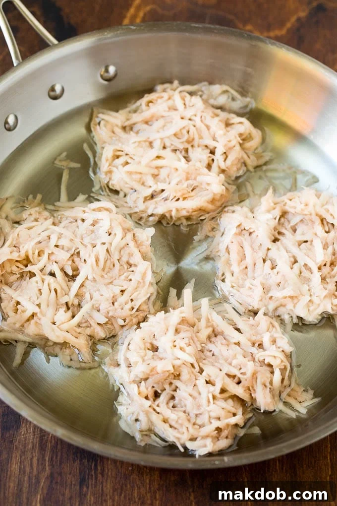 Shredded potato cakes in a pan of oil. Shredded potato cakes in a pan of oil.
