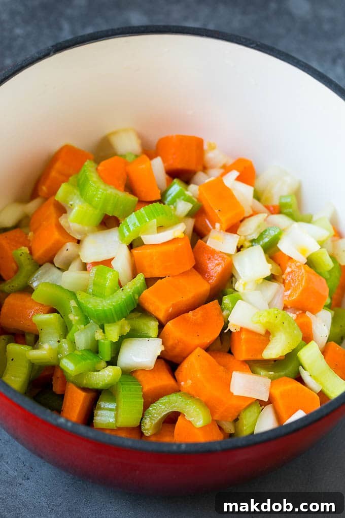 Carrots, celery and onion cooked in a red pot.