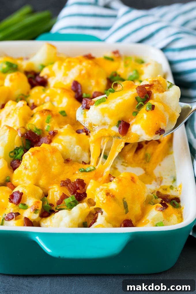 Delicious Cauliflower Casserole with a perfect golden crust, ready to be served. A spoon serving up a portion of creamy, golden-brown cauliflower casserole, revealing its cheesy interior.