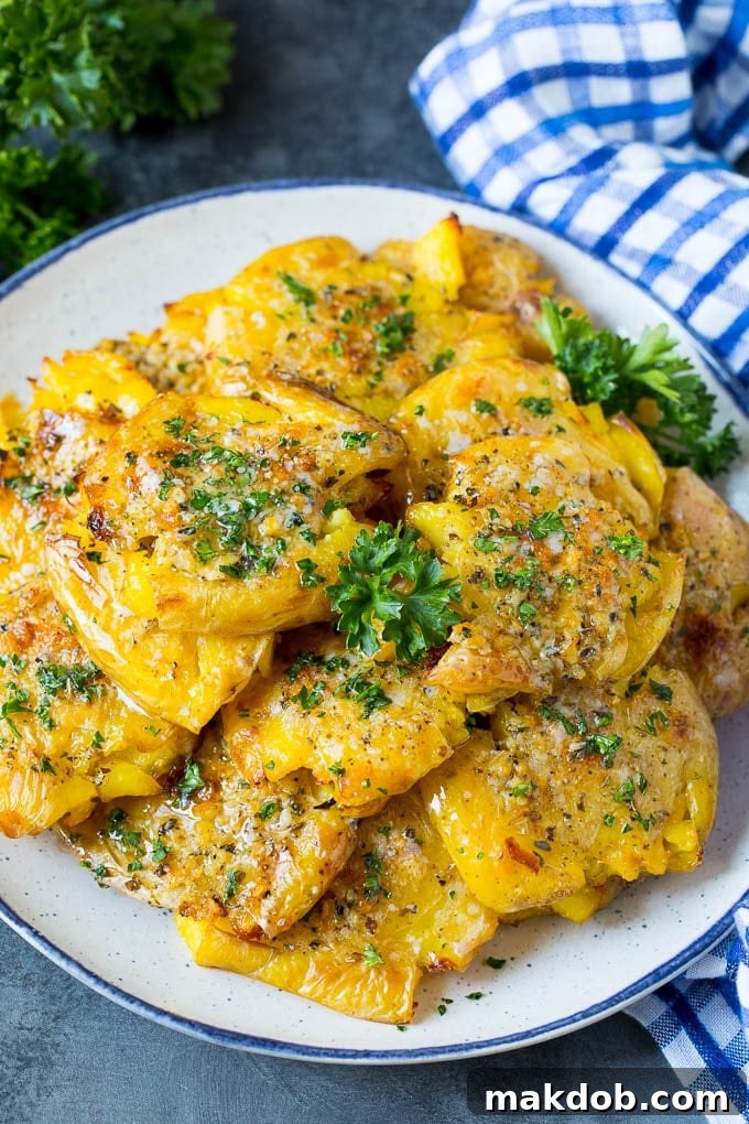 A beautiful serving plate of golden-brown smashed potatoes, delicately garnished with fresh green parsley, ready to be enjoyed.