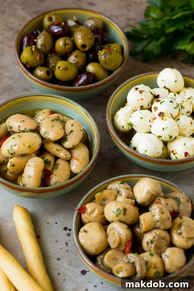 Bowls of mozzarella balls, marinated beans, mushrooms and olives.