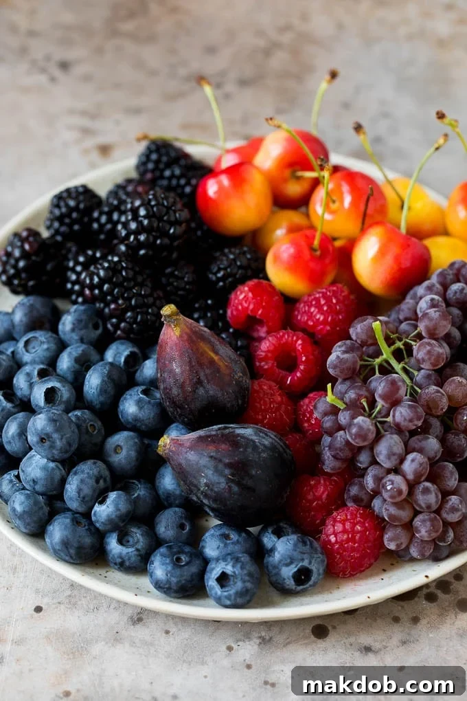 A plate of berries, cherries, grapes and figs.
