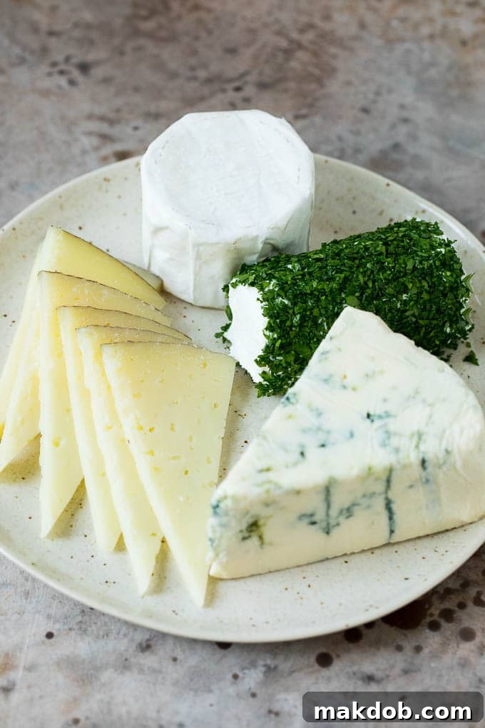 Four different types of cheese arranged on a plate.