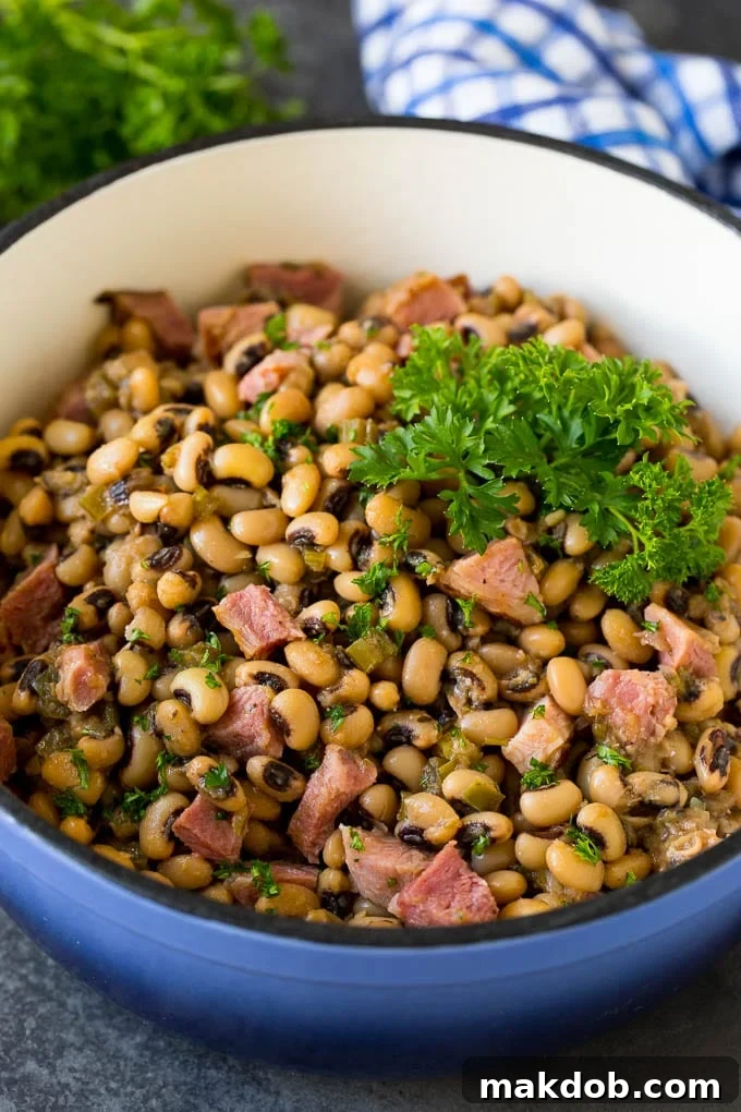 Hearty Hoppin' John: Black Eyed Peas, Ham, and Vegetables Served Over Rice A pot of Hoppin' John made with stewed black eyed peas, ham, and an assortment of colorful vegetables, ready to be served.