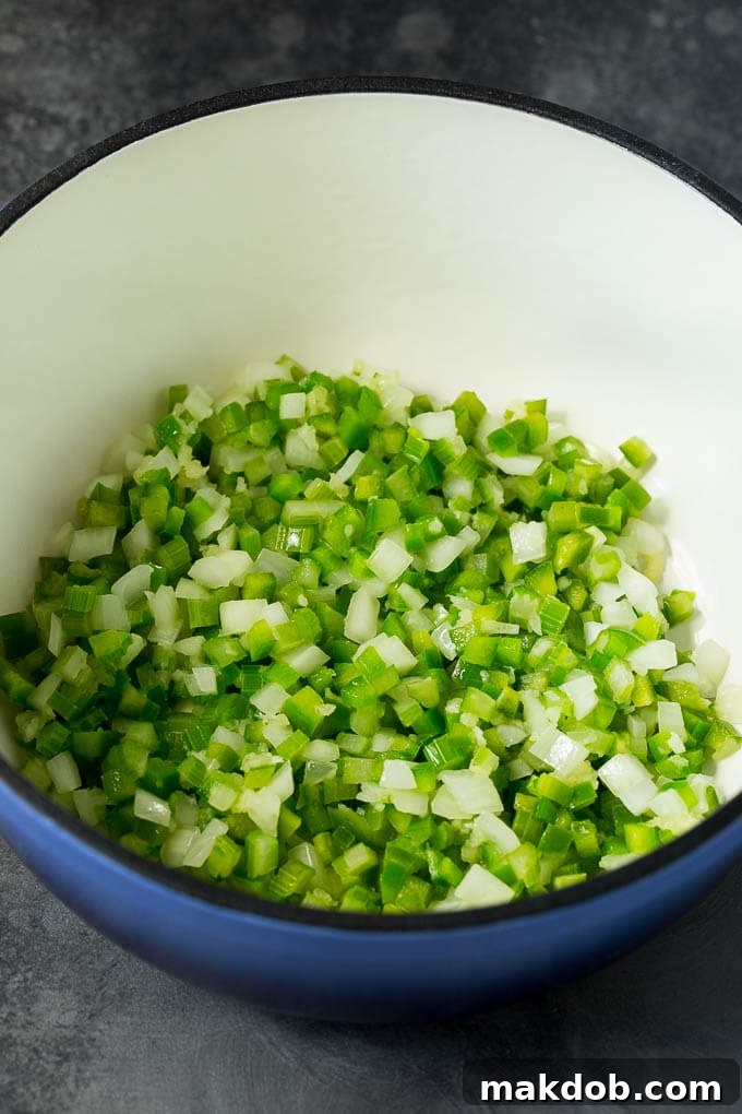 Sautéing the Aromatic Foundation: Onions, Celery, and Bell Peppers A close-up shot of chopped onions, celery, and bell peppers gently cooking in a pot with melted butter, forming the aromatic base for Hoppin' John.