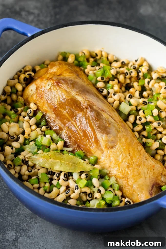 Ham Hock Infusing Flavor in Hoppin' John A large ham hock nestled among black eyed peas and vegetables in a pot, simmering to infuse deep, smoky flavor into the dish.