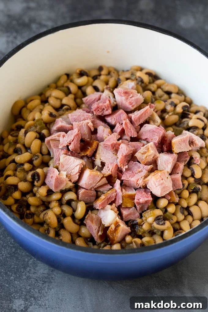 Diced Ham Blended with Black Eyed Peas in Hoppin' John Hearty diced ham mixed into a pot of perfectly cooked black eyed peas, showcasing the rich texture and appealing color of Hoppin' John.