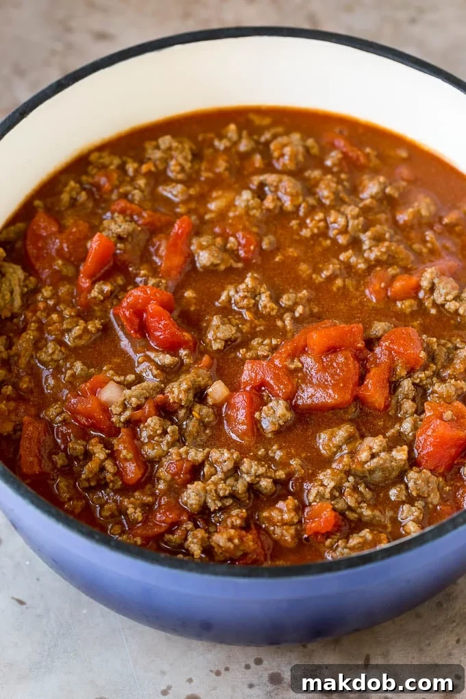 This beef chili is a blend of meat, tomatoes, spices and beans, all simmered together to make a delicious and hearty meal. Beef, tomatoes, seasonings and broth in a pot.