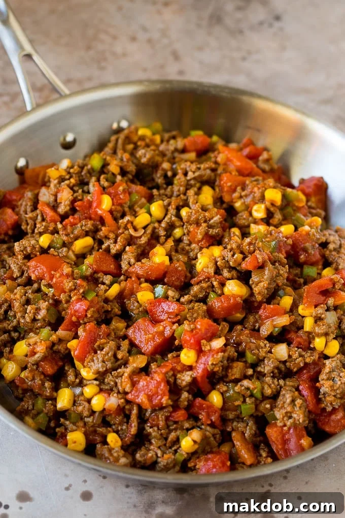 Ultimate Taco Lasagna 3 A close-up shot of the savory ground beef and colorful vegetables simmering together in a pan, ready to become the heart of the taco lasagna.
