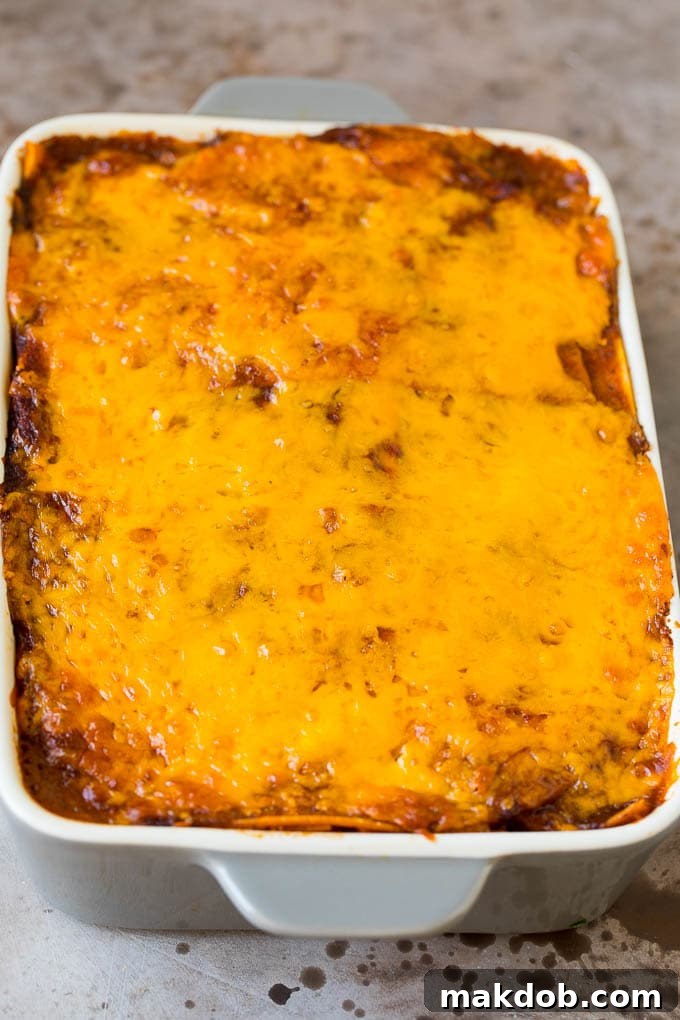 Ultimate Taco Lasagna 5 A golden-brown baked casserole, revealing delicious layers of tortillas, seasoned meat, and bubbling cheese, fresh from the oven.