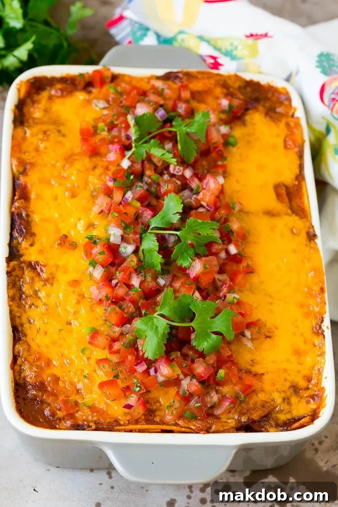 Ultimate Taco Lasagna 6 A full pan of golden-baked taco lasagna, generously topped with vibrant fresh salsa and a scattering of bright green cilantro, ready to be served.