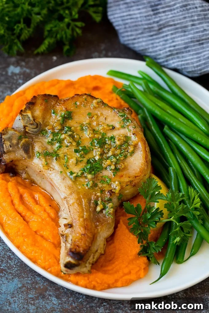 A complete meal featuring brined pork chops and colorful side dishes. A delicious plate of brined pork chops served with sweet potatoes and green beans.