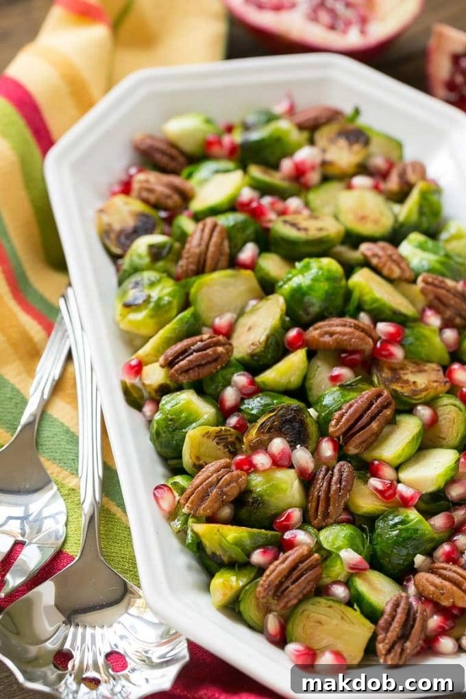 Cooked Brussels sprouts in an elegant serving dish, with serving utensils alongside, ready for the table.