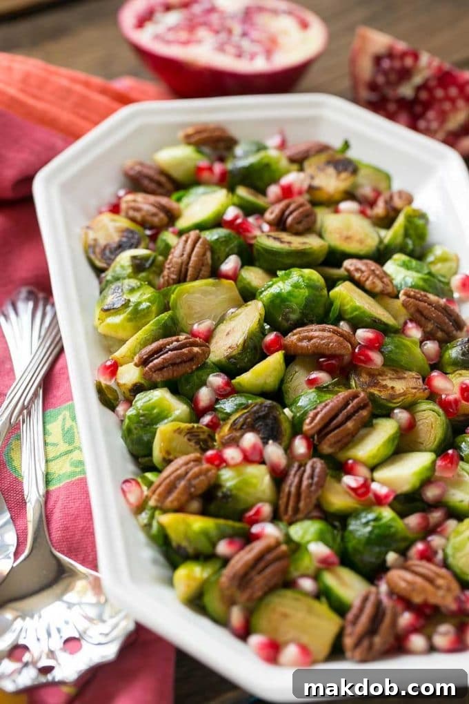 A beautifully seasoned dish of Brussels sprouts, garnished with pomegranate and pecans, ready to be served.