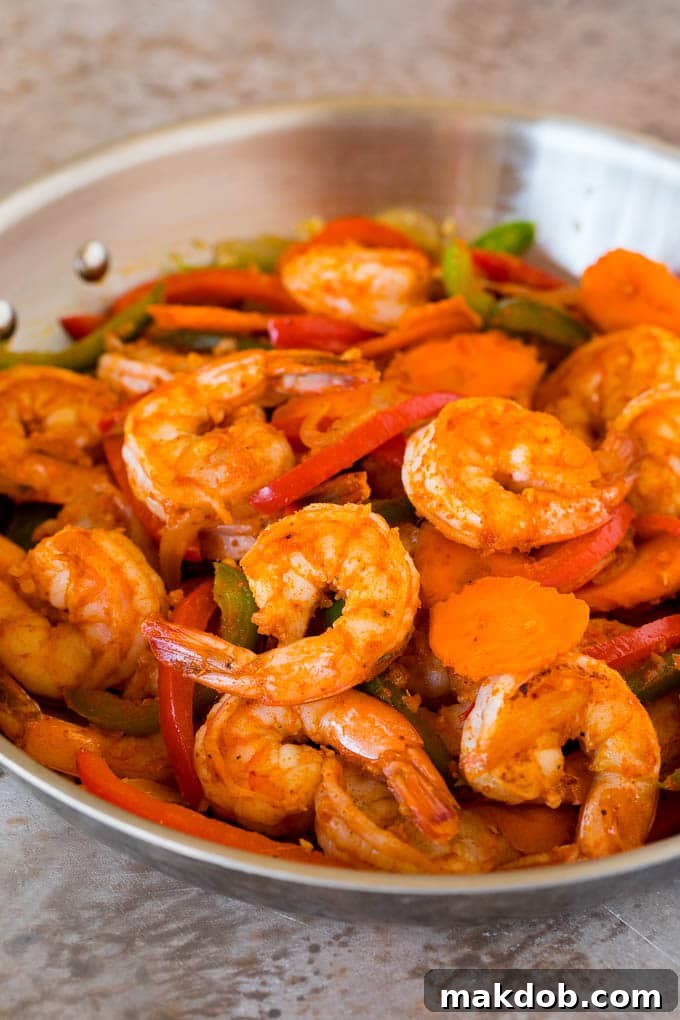Shrimp, curry paste and vegetables in a pan.