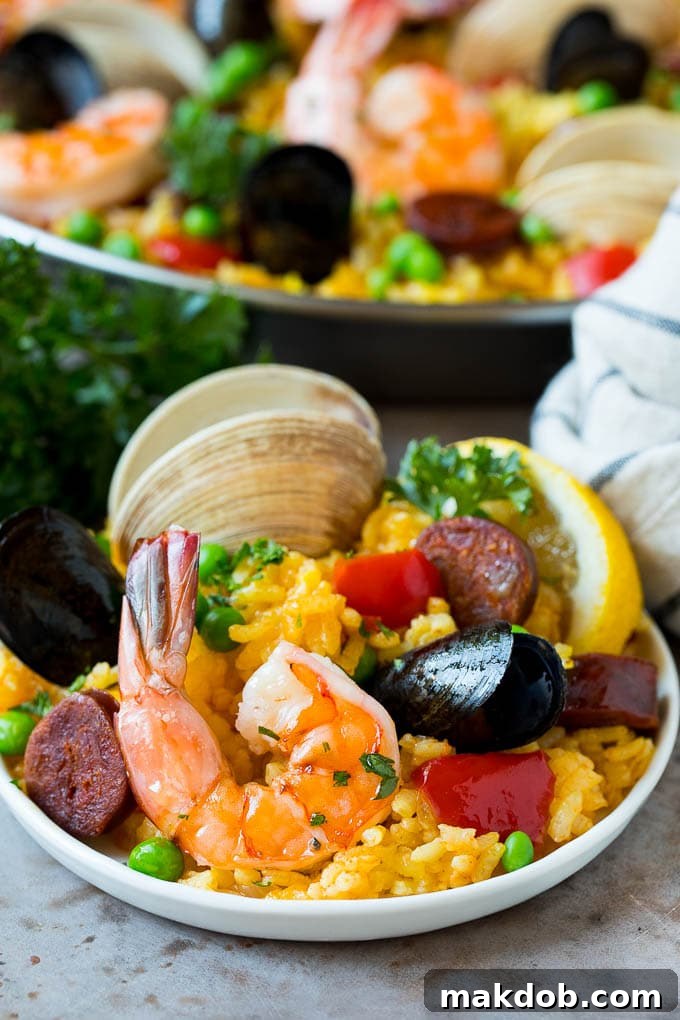 A plate of seafood paella garnished with parsley. A plate of seafood paella garnished with parsley.