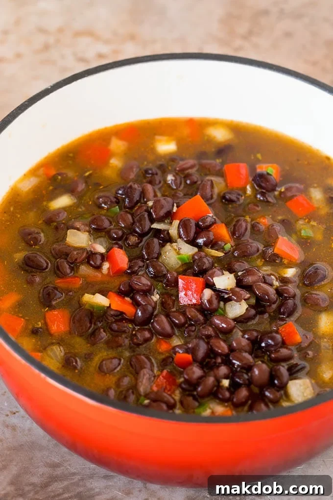 A pot of beans, broth and vegetables.
