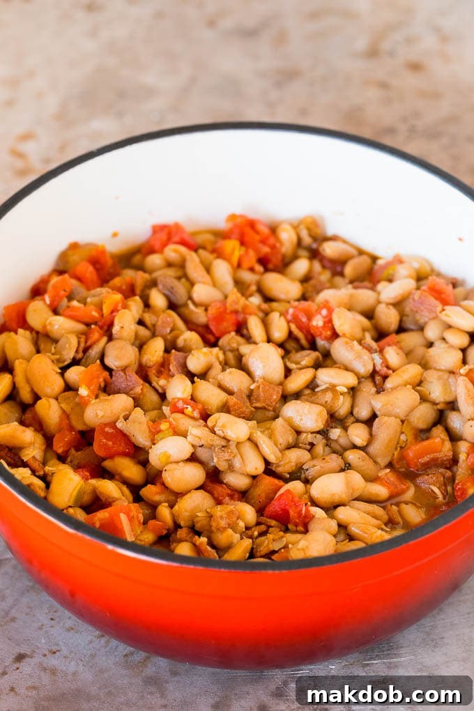 A pot of pinto beans cooked with bacon and tomatoes.