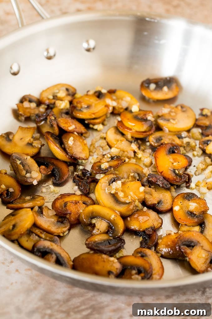 Sauteed mushrooms and shallots in a skillet.