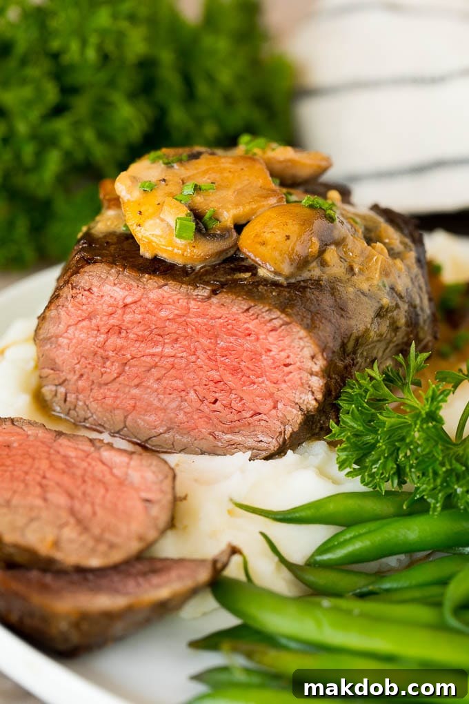 Sliced Steak Diane served with mashed potatoes and green beans.