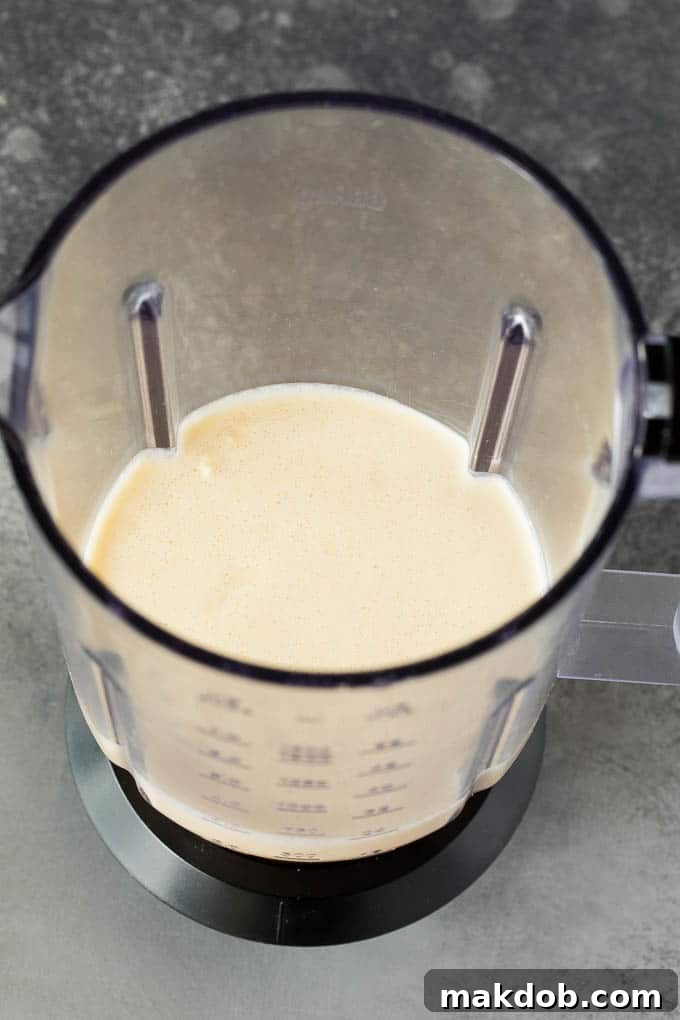 Pancake batter being pureed in a blender for blintzes.