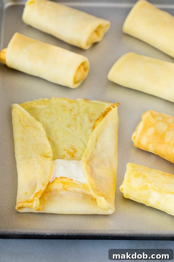 A delicate crepe with creamy cheese filling ready to be folded.