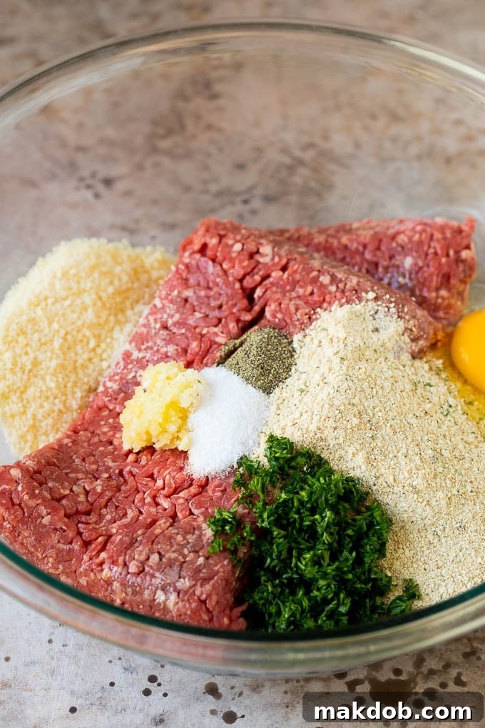Ground beef, parsley, breadcrumbs and spices in a bowl ready for mixing.