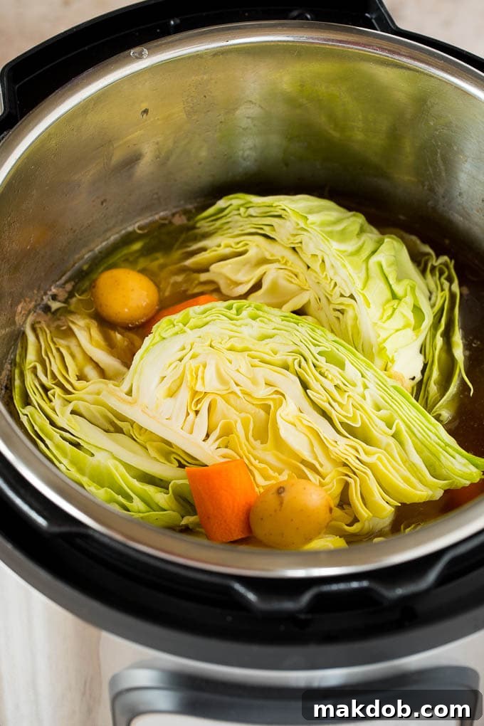 Vegetables Placed in Instant Pot for Cooking Cabbage wedges, potatoes and sliced carrots arranged in an Instant Pot before cooking.