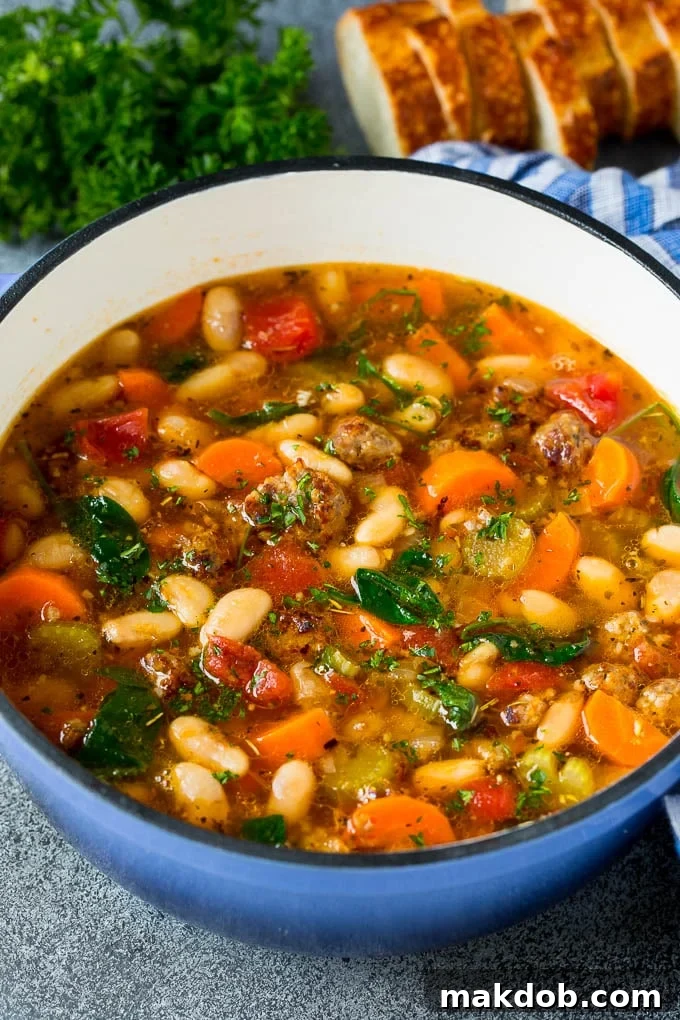 Tuscan White Bean Soup in a Pot A large pot brimming with hearty Tuscan white bean soup, featuring golden-brown Italian sausage, colorful vegetables, and creamy beans, all ready to be served.