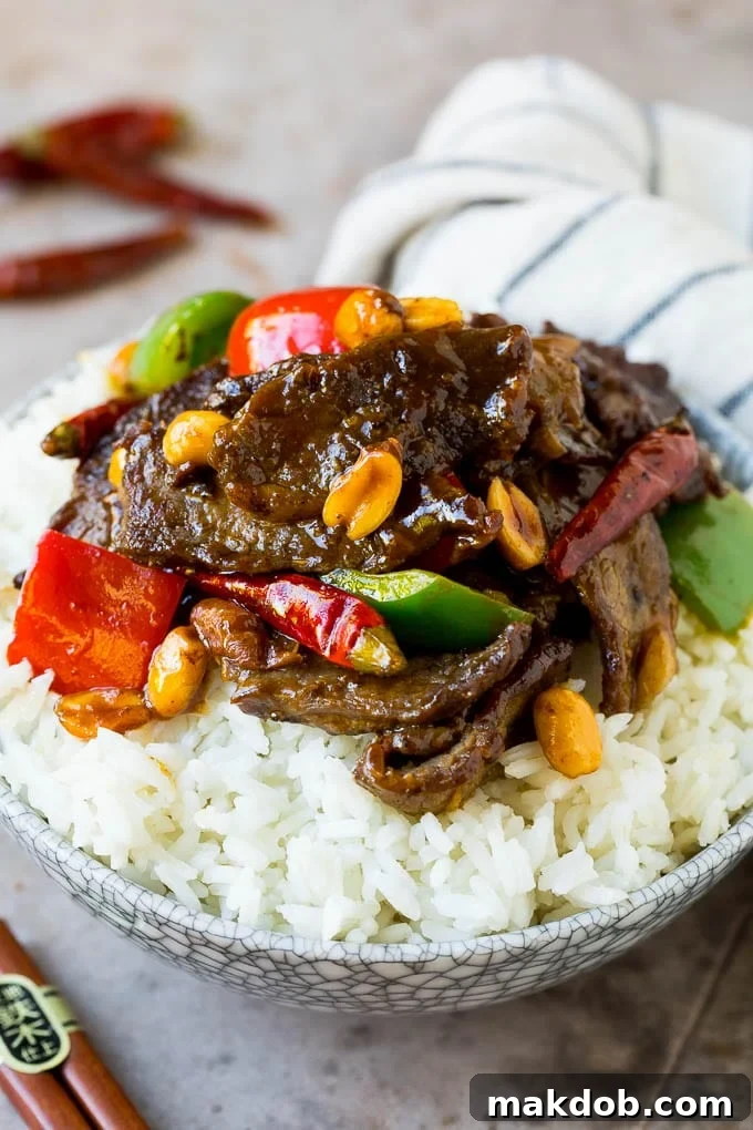 This kung pao beef is a combination of thinly sliced steak, bell peppers, onions and roasted peanuts, all in a savory and spicy sauce. Kung pao beef served over a bowl of rice.