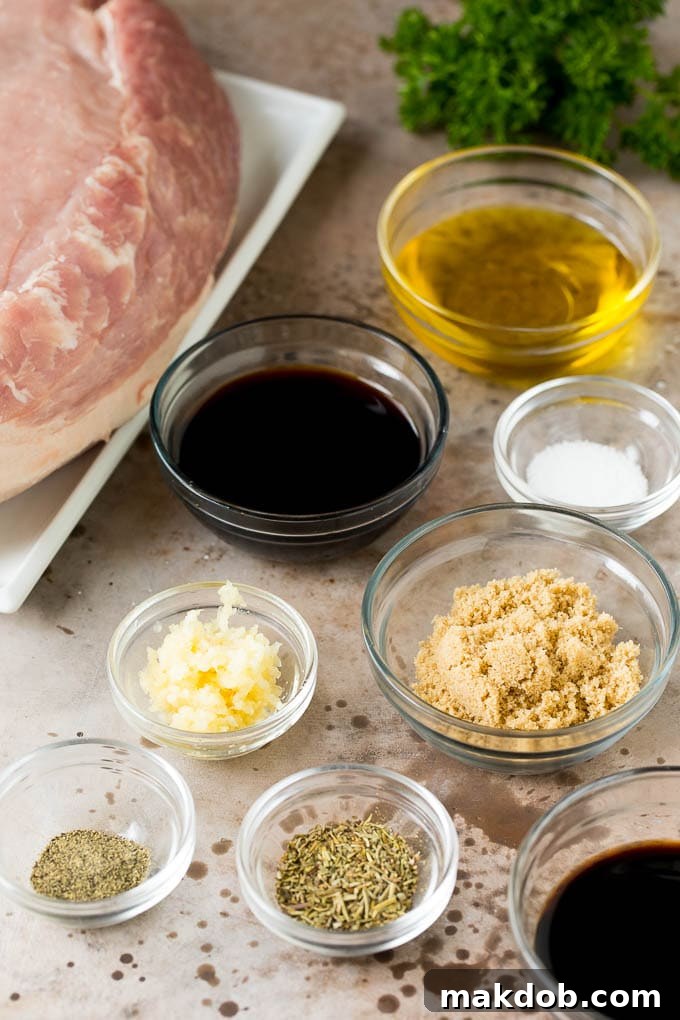 This crock pot pork roast is tender pork loin simmered in a slow cooker in a rich and flavorful gravy. Bowls of herbs, spices and seasonings next to a piece of pork loin, ready for cooking.