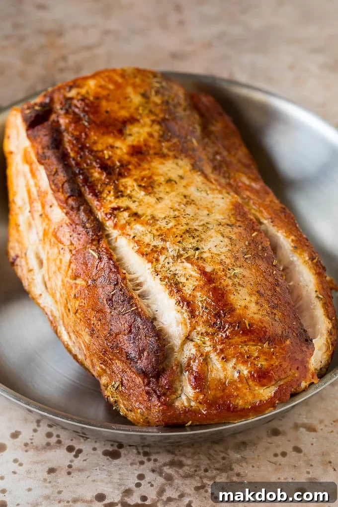 This crock pot pork roast is tender pork loin simmered in a slow cooker in a rich and flavorful gravy. A seared pork loin in a pan, before being transferred to the slow cooker.