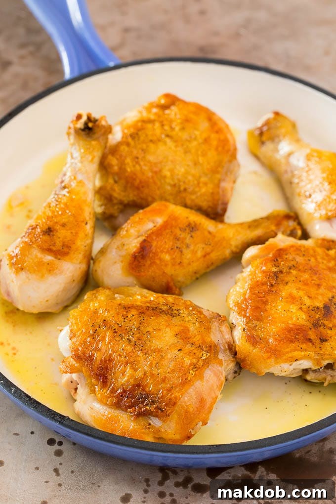 Browned chicken pieces in a skillet.