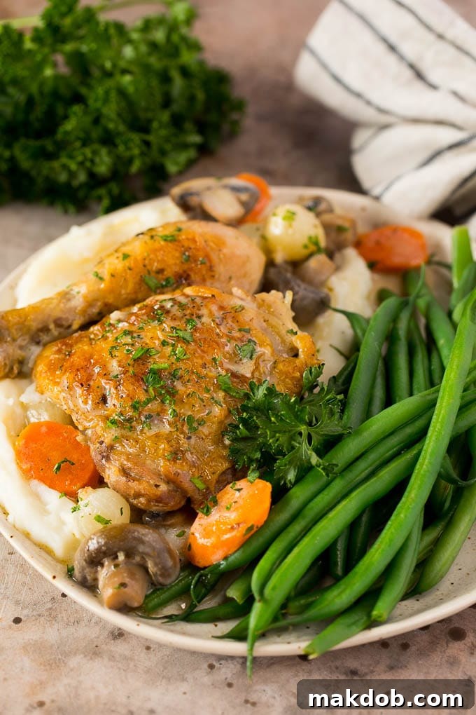 A plate of chicken fricassee served with mashed potatoes and green beans.
