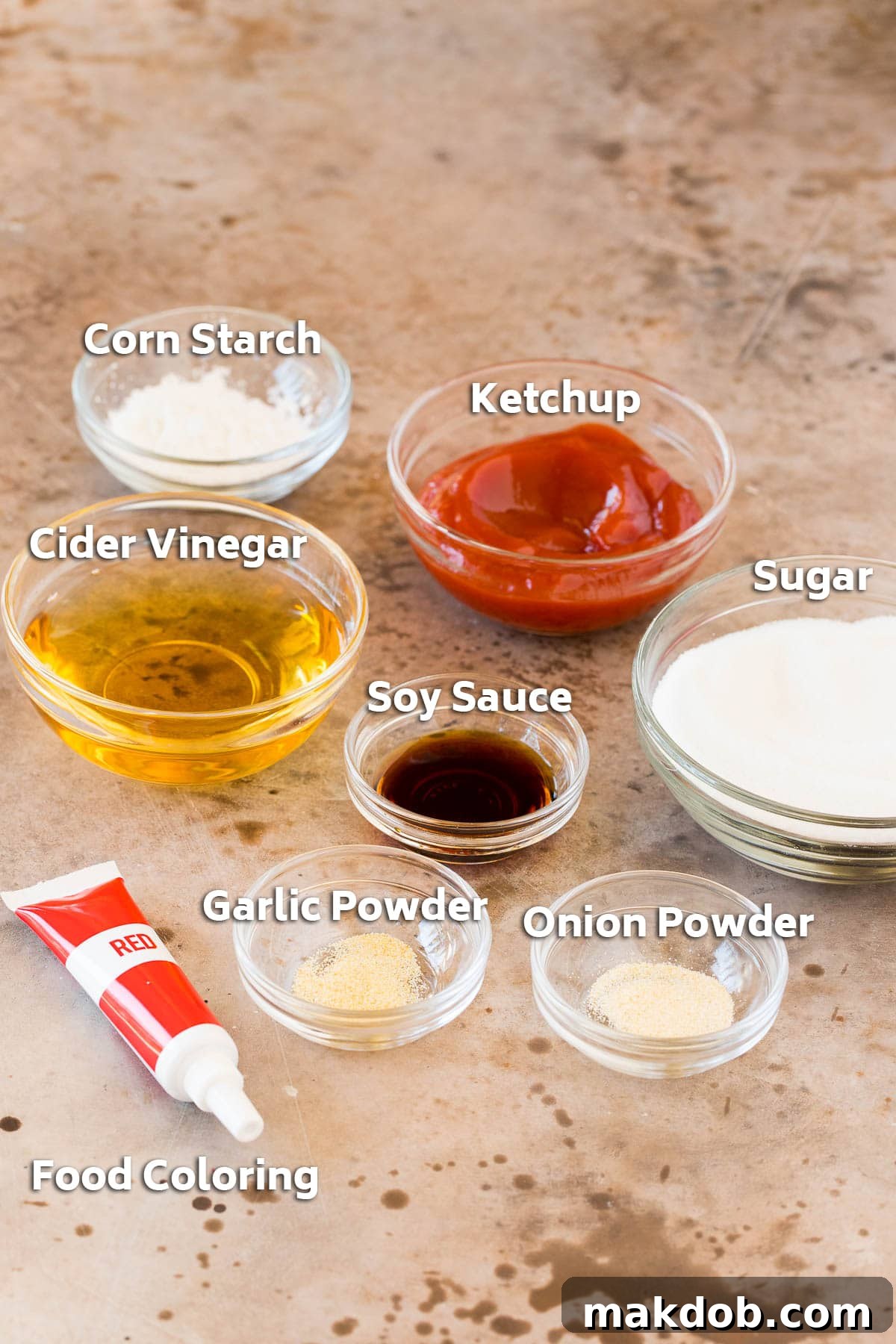 Zesty Sweet Harmony Sauce 2 Various sweet and sour sauce ingredients, including granulated sugar, apple cider vinegar, soy sauce, ketchup, cornstarch, garlic powder, and onion powder, displayed in small bowls.