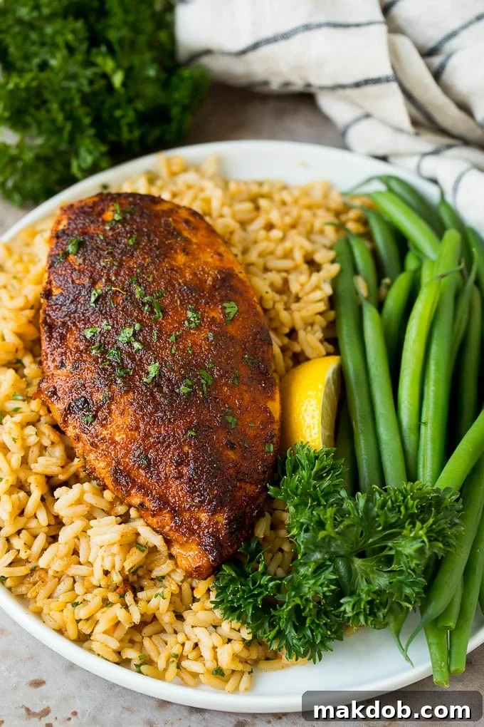 Blackened Chicken with Rice Perfectly blackened chicken breast served over a bed of fluffy rice, showcasing a delicious meal made with homemade seasoning.