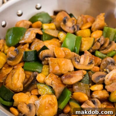 A pan of almond chicken stir fry with vegetables.