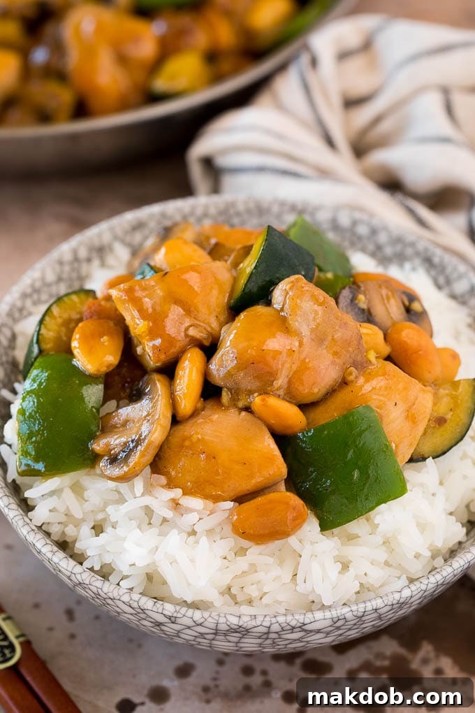 Almond chicken served over steamed rice in a bowl.