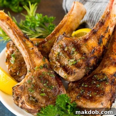 Flame-Kissed Lamb Chops 7 Grilled lamb chops on a plate garnished with parsley and lemon.
